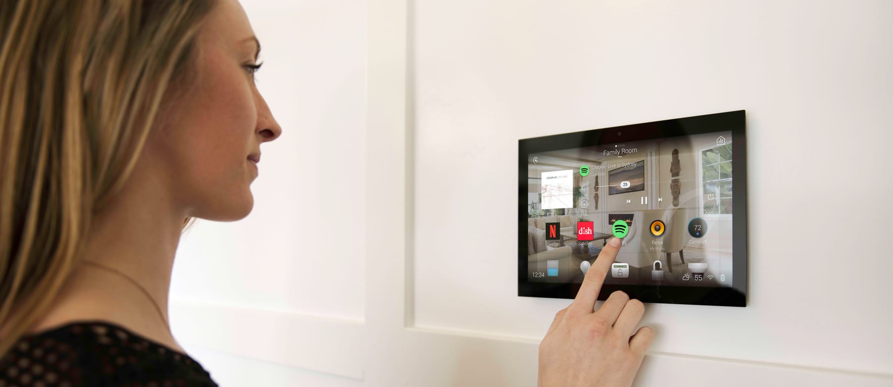 A professional operating a wall-mounted Control4 touchscreen